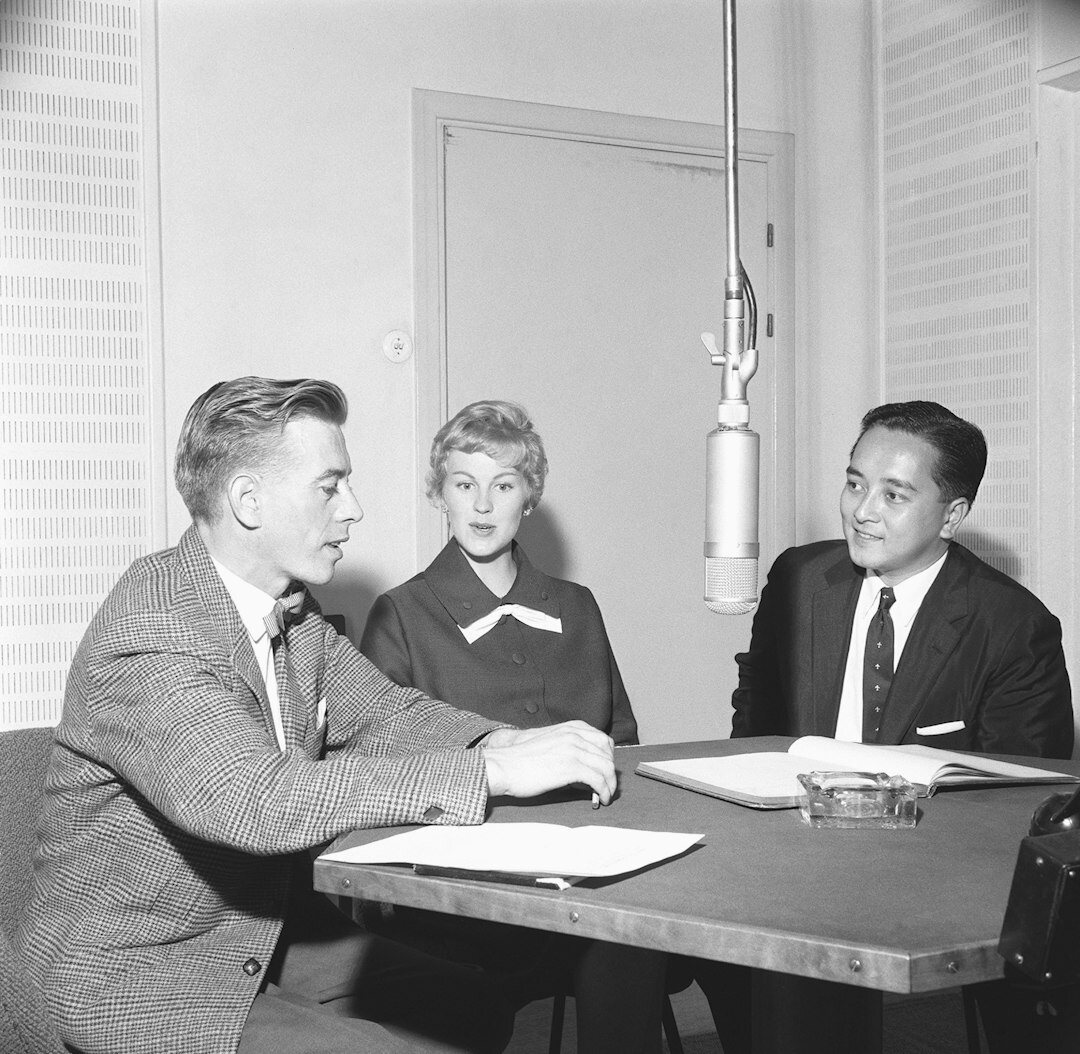 Small editorial team discussing a layout around a table
